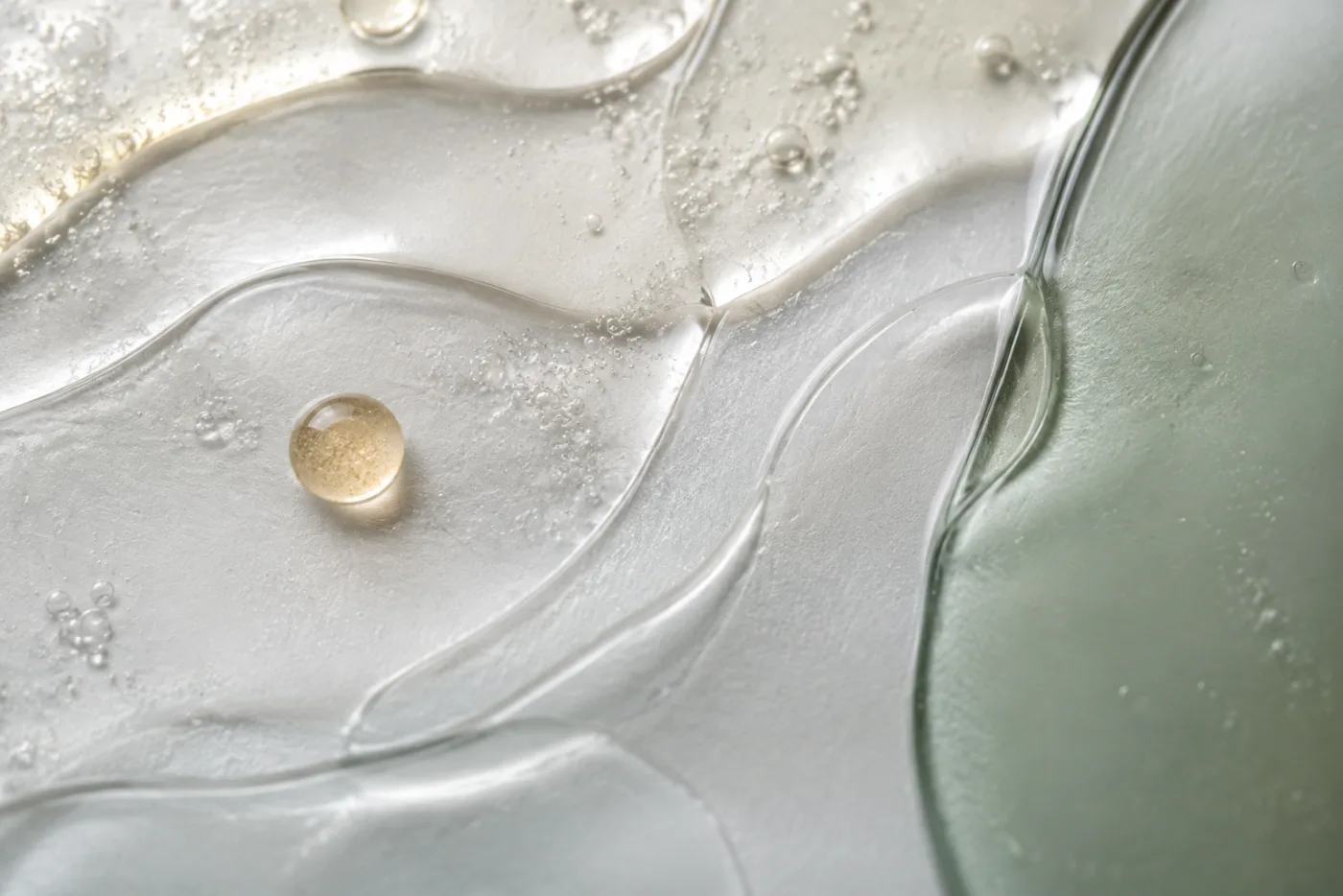 Translucent skincare textures layered across frosted glass